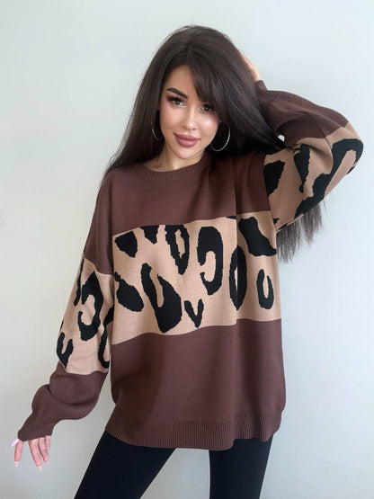 Woman wearing a brown sweater with leopard print pattern against a plain background