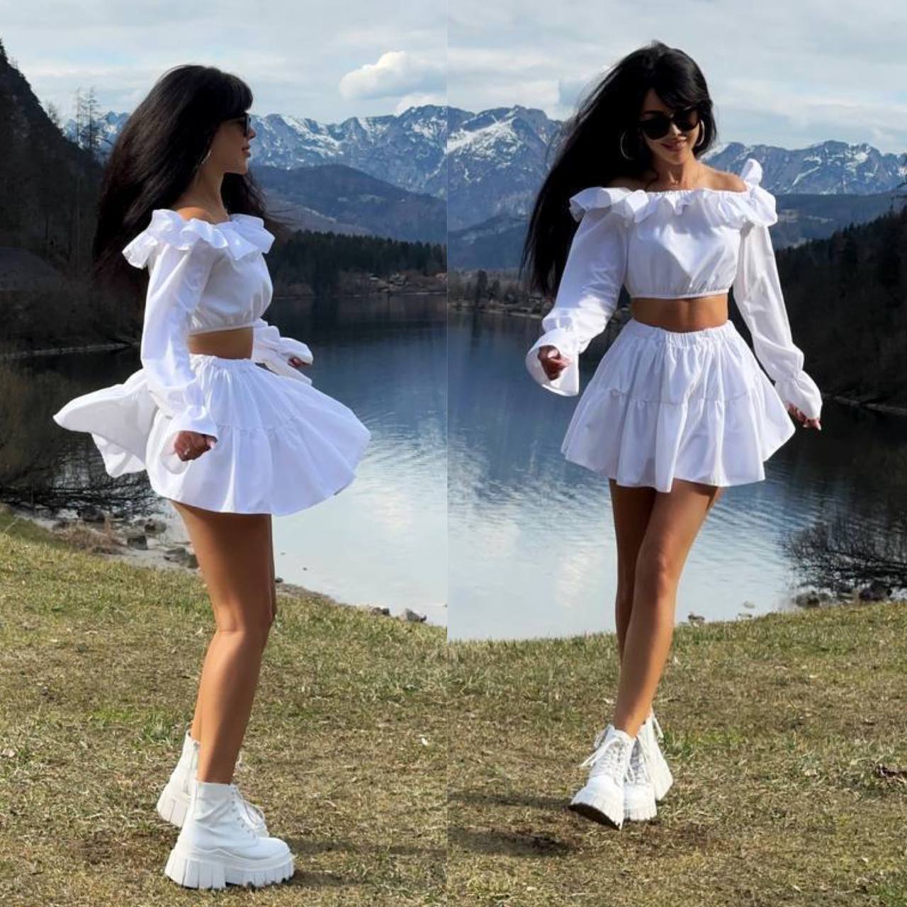 Woman in a white outfit standing by a lake with mountains in the background