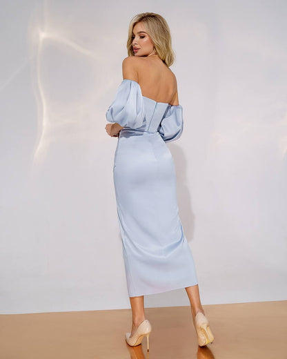 Woman wearing a light blue off-shoulder dress against a white background