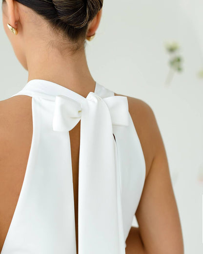 White sleeveless top with a bow detail on a blurred background
