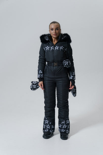Person wearing a black snowsuit with star patterns on a white background