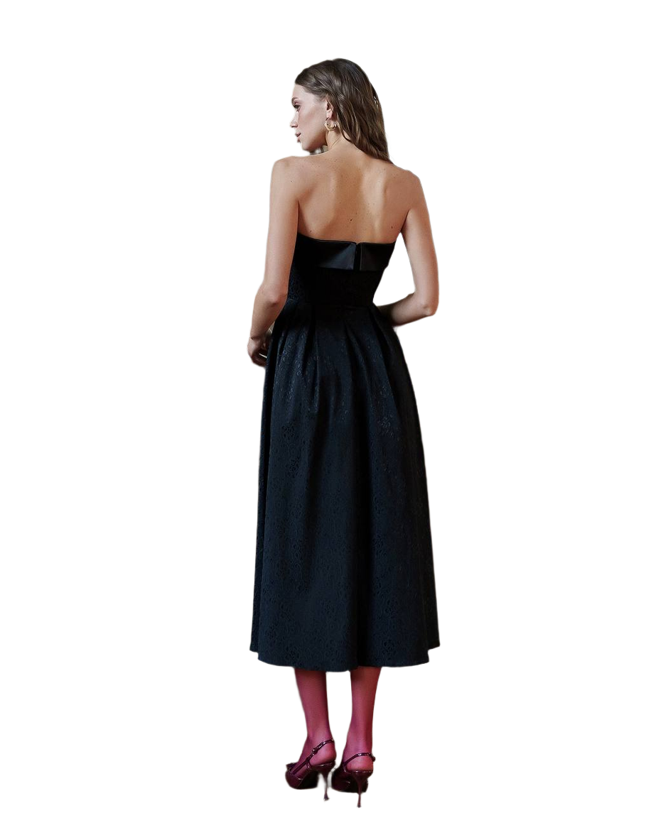 Woman wearing a black strapless dress on a white background