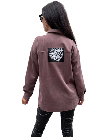 Person wearing a brown jacket with a logo on the back against a white background