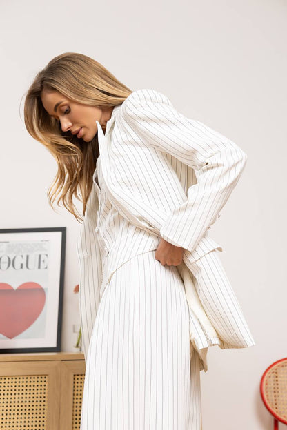 Woman wearing a white pleated dress with a blurred background