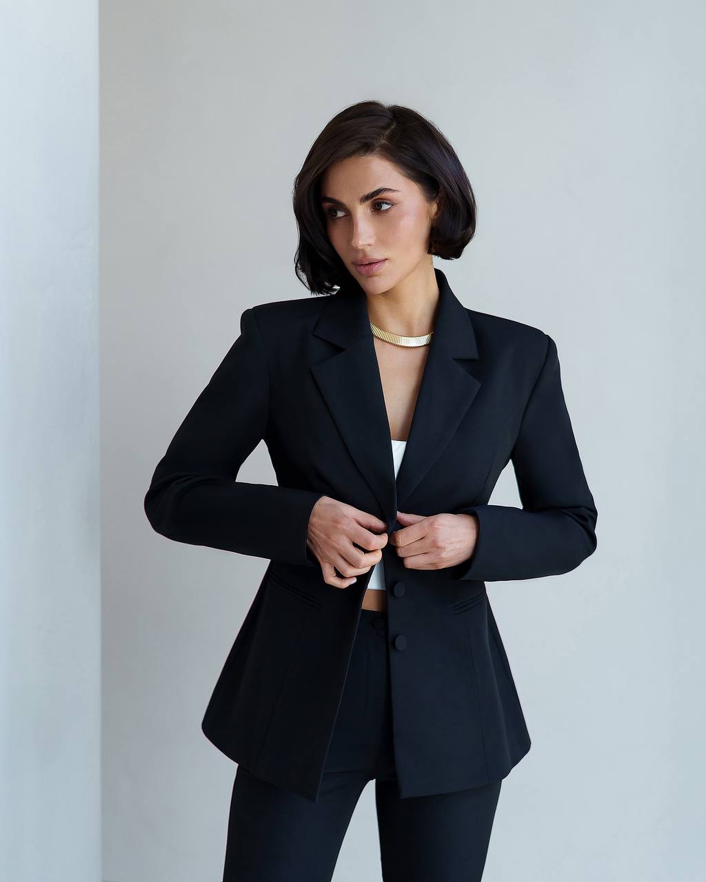 Woman wearing a black blazer against a plain background