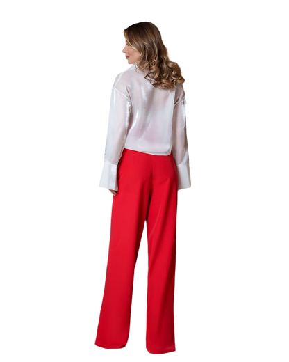 Woman wearing a white blouse and red pants on a white background