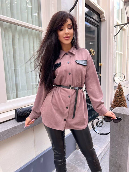 Woman wearing a pink coat with black accents in an urban setting