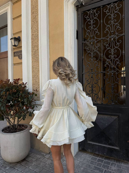 Woman in a white dress standing in front of a decorative door.