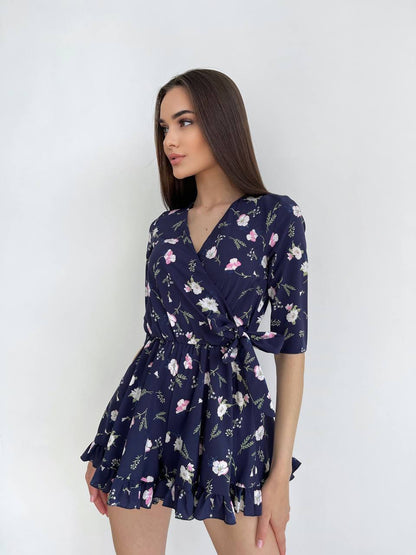Woman wearing a navy floral dress against a white background