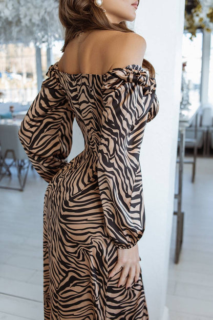 Woman wearing a zebra print off-shoulder dress in an indoor setting.