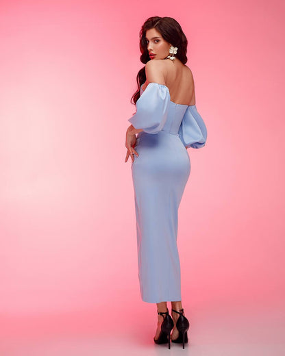 Woman wearing a light blue off-shoulder dress against a pink background