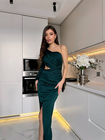 Woman in a green dress standing in a modern kitchen.