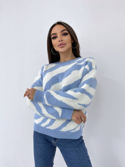Woman wearing a blue and white patterned sweater against a plain background