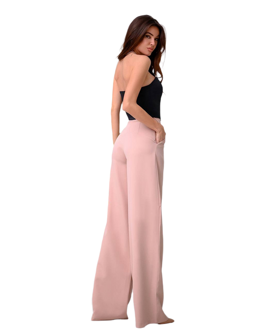 Woman wearing a black top and pink wide-leg pants on a white background