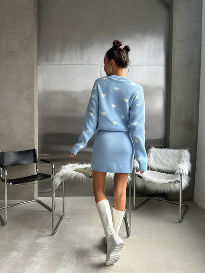 Person wearing a light blue outfit with heart patterns in a modern room.