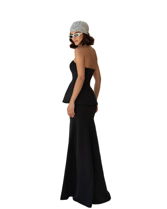 Woman wearing a black evening gown and patterned headband on a white background