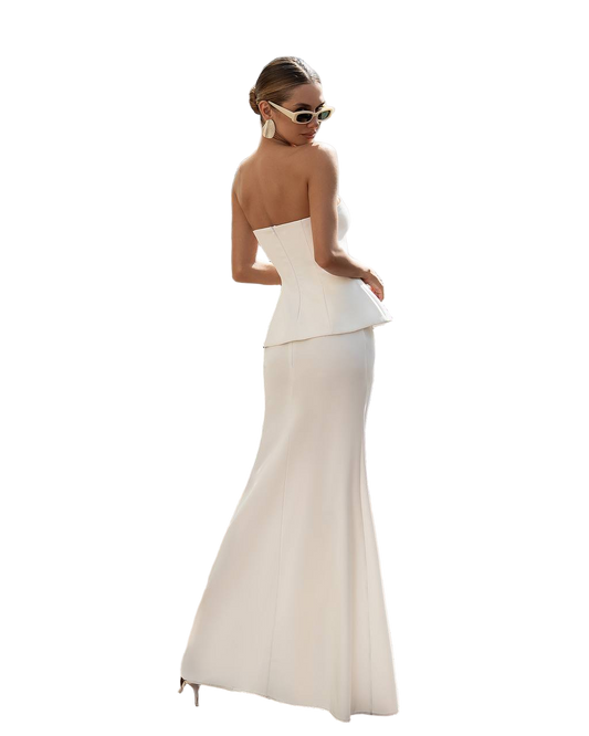 Woman wearing a white strapless gown with a fitted bodice and flared skirt on a white background