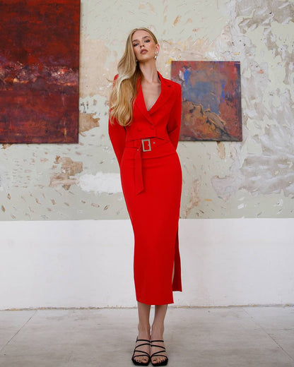 Woman in a red dress standing in an art gallery with abstract paintings on the wall.