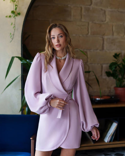 Woman wearing a light purple dress with puffed sleeves in an indoor setting.