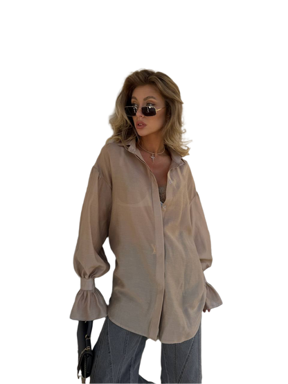 Woman wearing a beige blouse and sunglasses on a white background