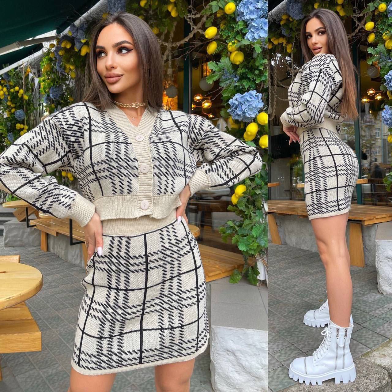 Woman wearing a black and white checkered outfit in an outdoor setting.