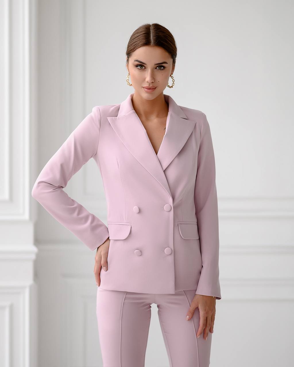Woman wearing a pink suit against a white background