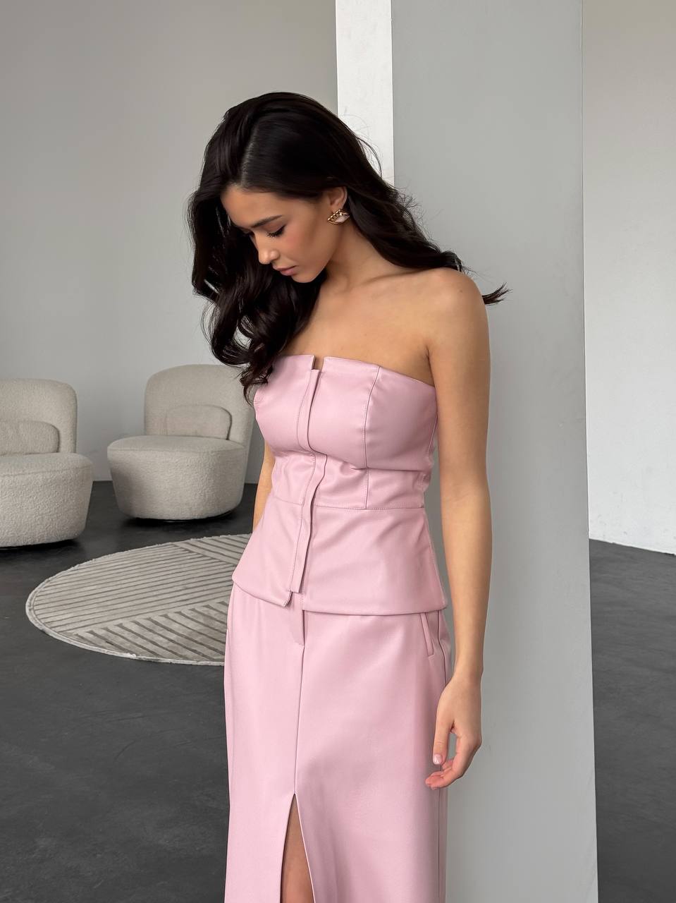 Woman wearing a pink strapless dress in an indoor setting