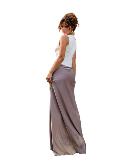 Woman wearing a white sleeveless top and long beige skirt on a white background