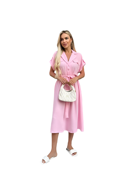 Woman wearing a pink dress holding a white handbag on a white background