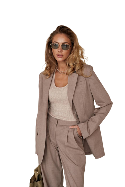 Woman wearing a beige suit and sunglasses on a white background