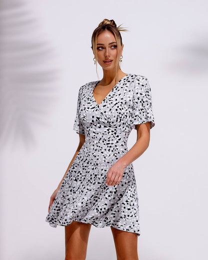 Woman wearing a black and white patterned dress against a plain background