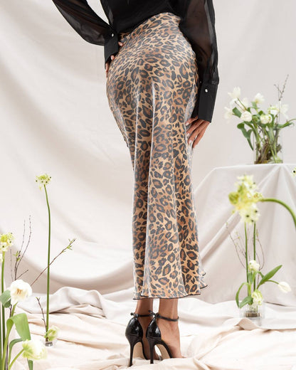 Person wearing leopard print pants with a plain background