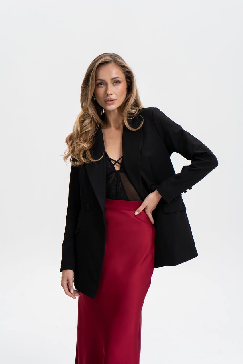 Woman wearing a black blazer and red skirt on a white background