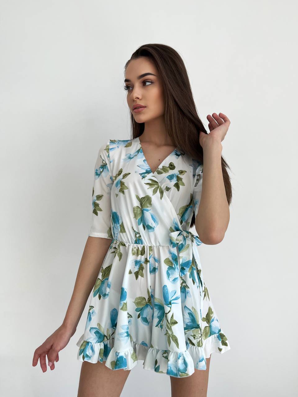Woman wearing a floral dress against a plain background
