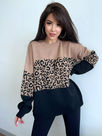 Woman wearing a brown sweater with leopard print sleeves against a light blue background