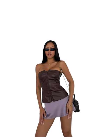 Woman wearing a brown top and purple skirt with sunglasses on a white background