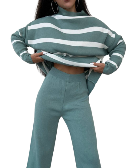 Person wearing a green and white striped sweater and matching pants on a white background