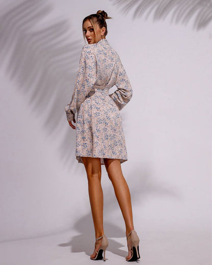 Woman wearing a floral dress against a plain background