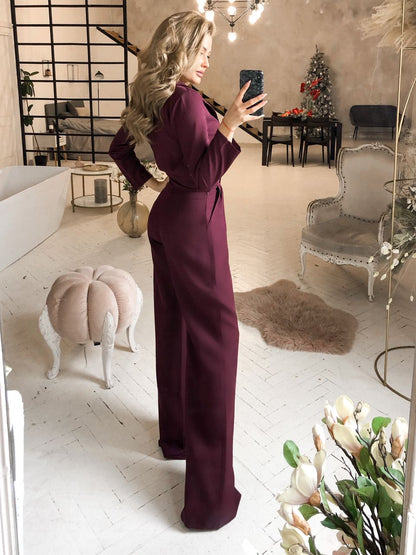 Woman in a purple dress taking a mirror selfie in a stylish room with decor elements.