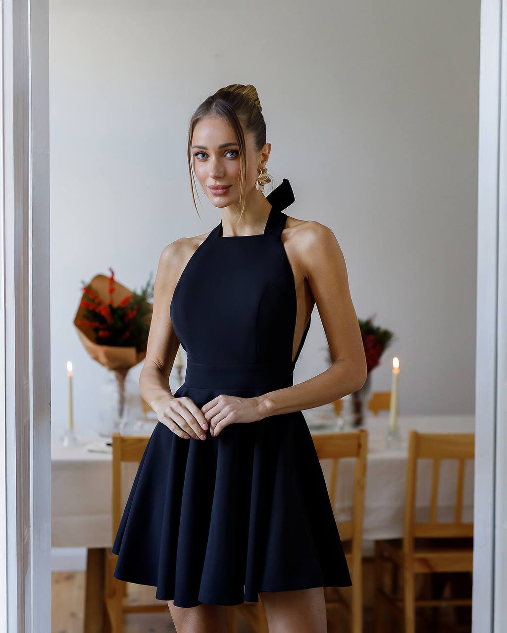 Woman wearing a black dress in a dining room setting
