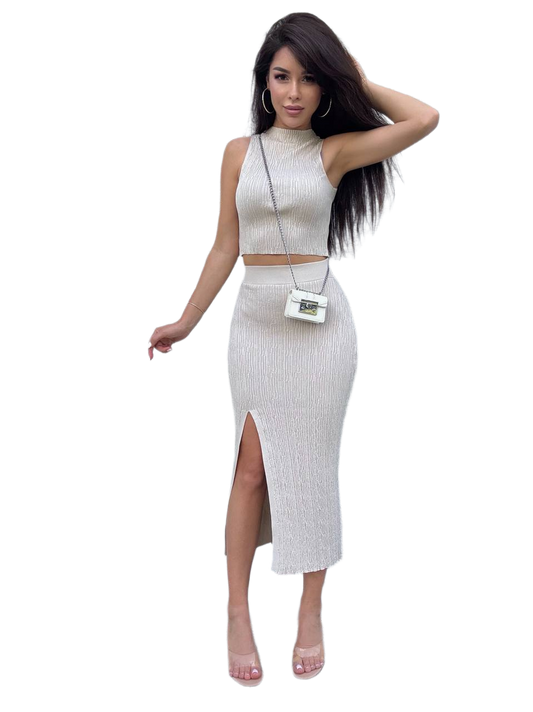 Woman wearing a white ribbed outfit with a high slit skirt on a white background