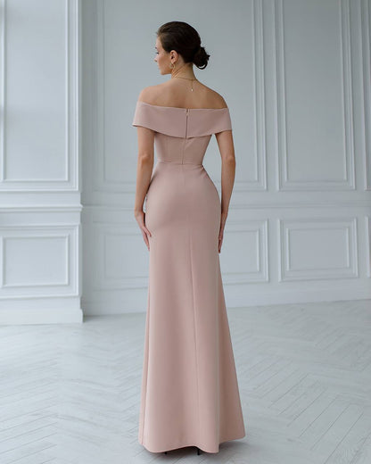 Woman wearing a pink off-shoulder gown in a white room