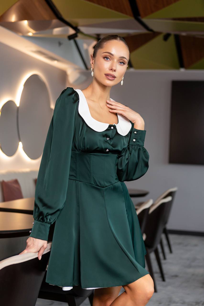 Woman in a green dress posing in an indoor setting