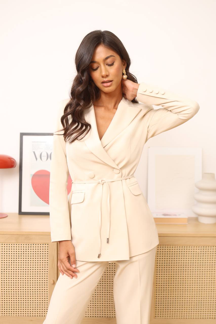 Woman wearing a beige suit in an office setting