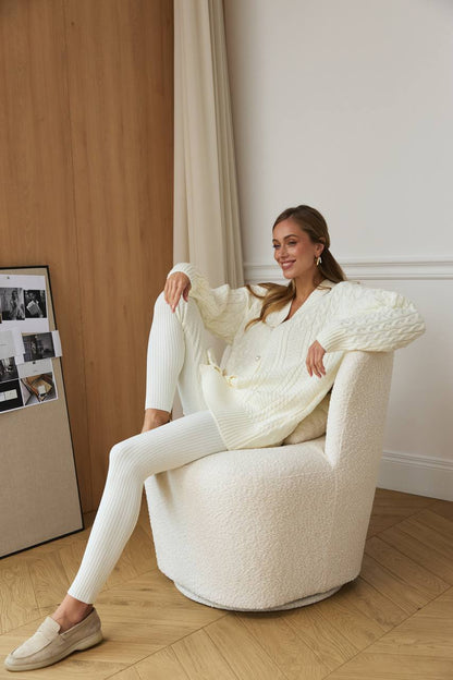 Woman sitting on a white chair in a room with wooden floor and light-colored walls.