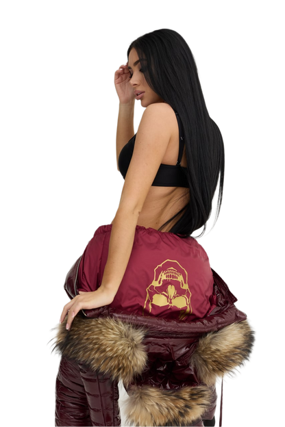 Woman holding a maroon bag with fur trim against a white background