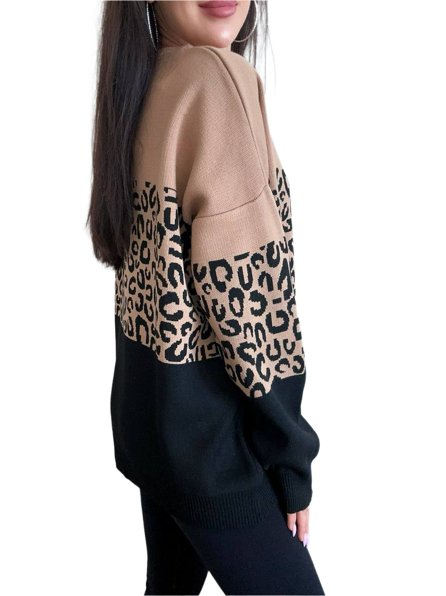 Person wearing a beige sweater with leopard print sleeves on a white background