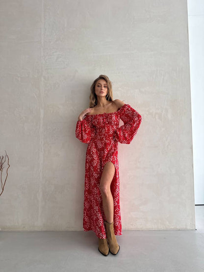 Woman wearing a red floral dress against a plain background