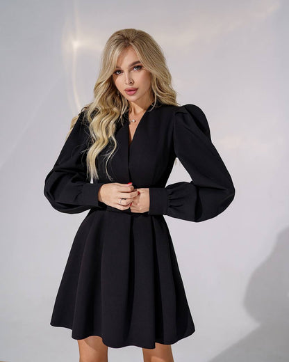 Woman wearing a black dress against a plain background