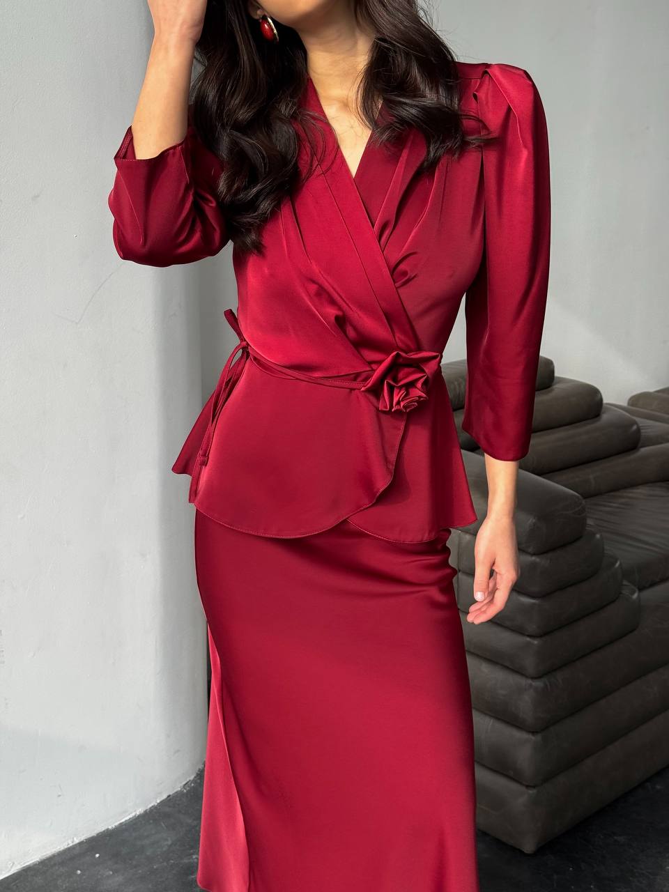 Woman wearing a red satin outfit with a gray background